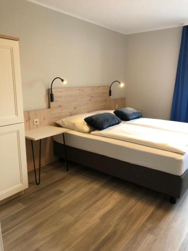 a bedroom with a large bed and a desk at Gästehaus am Elberadweg by Hotel Alte Fischerkate in Mödlich