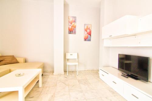 a living room with a couch and a television at Apartamentos Centro 1 El Puerto de Santa Maria in El Puerto de Santa María
