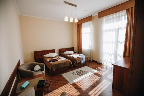 Cette chambre comprend deux lits, un canapé et une chaise. dans l'établissement Карпаты, à Khoust
