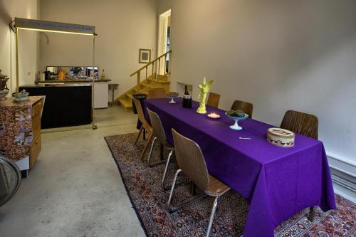 une table violette avec des chaises dans une pièce dans l'établissement Pension Friedrich-Wilhelm, à Berlin