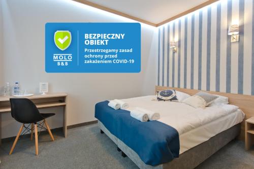 a hotel room with a bed and a desk at B&B Molo in Sopot