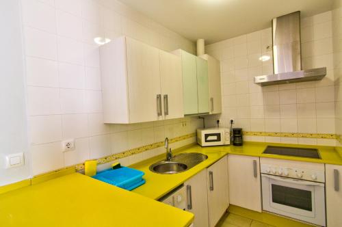 a kitchen with a sink and a yellow counter top at Apartamentos Centro 1 El Puerto de Santa Maria in El Puerto de Santa María