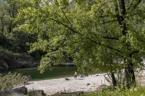 a group of people standing on a beach next to a river at Hotel al Ponte Antico in Intragna