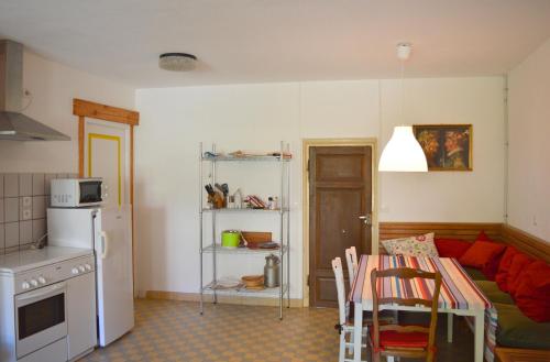 a kitchen and living room with a table and a couch at La petite maison in Grancey-le-Château