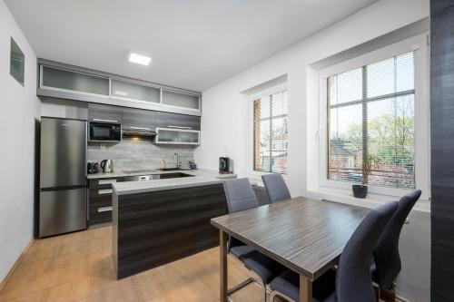 a kitchen with a wooden table and a dining room at Apartmá SunGarden Liberec in Liberec