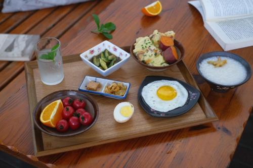 杭州市にあるHangzhou JiuYueJi Bed&Breakfastの木製テーブルの朝食用食品のトレイ