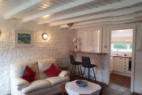 un salon avec un canapé et une cuisine dans l'établissement Self Catering - Gardeners Cottage, à Wexford