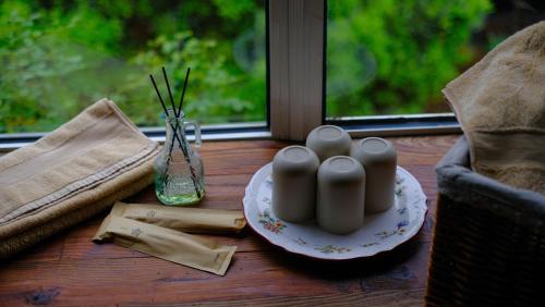 a table with a plate and a candle and a window at Hangzhou JiuYueJi Bed&Breakfast in Hangzhou