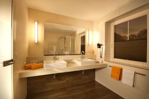 baño con 2 lavabos y espejo grande en Hotel Garni Villa Knauer, en Mayrhofen