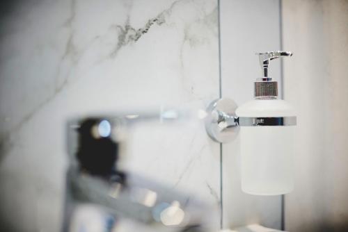 a bathroom with a soap dispenser on the wall at Hotel Buninn in Odesa