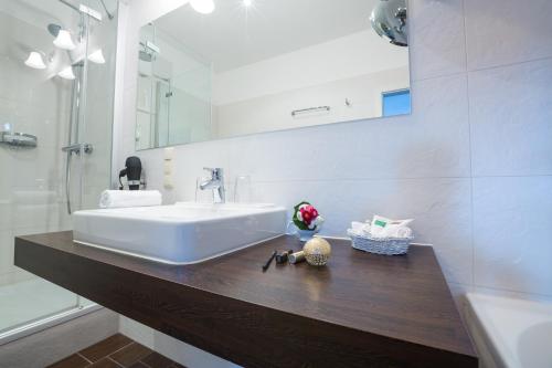 a bathroom with a white sink and a mirror at Romantik Hotel Schwanefeld & Spa in Meerane