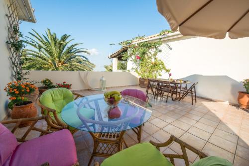 a patio with a glass table and chairs at Villa Phoenix in Keri
