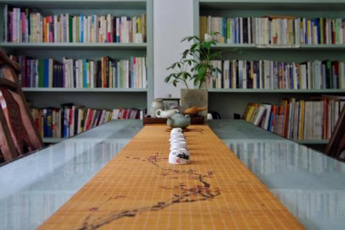 a long table in a library with books at Hangzhou JiuYueJi Bed&Breakfast in Hangzhou