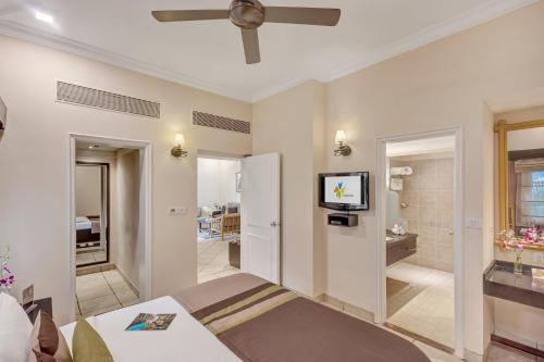 a bedroom with a bed and a ceiling fan at Club Mahindra Emerald Palms, Goa in Varca