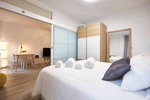 a bedroom with a large white bed and a table at Apartment SAN MIGUEL in Madrid