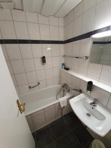 a bathroom with a sink and a bath tub at Pension Seibel in Munich