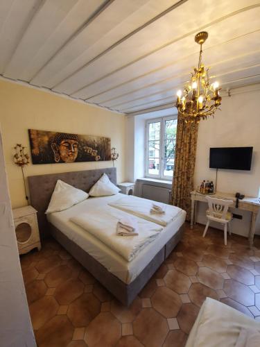 a bedroom with a large bed and a chandelier at Pension Seibel in Munich