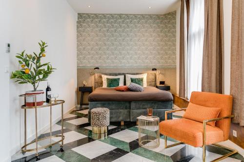 1 dormitorio con 1 cama y 1 silla en Brasss Hotel Suites, en Haarlem