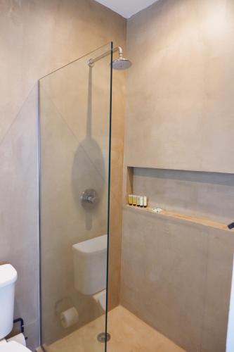 a bathroom with a glass shower with a toilet at Stay at Mare in San Juan