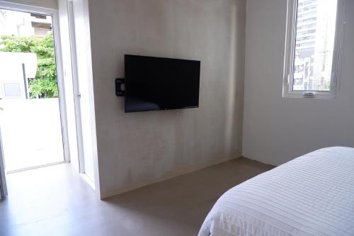 a bedroom with a flat screen tv on a wall at Stay at Mare in San Juan