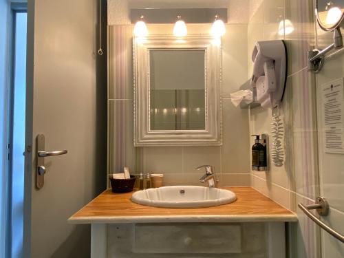 a bathroom with a sink and a mirror at Hôtel Le Colombier in Moustiers-Sainte-Marie