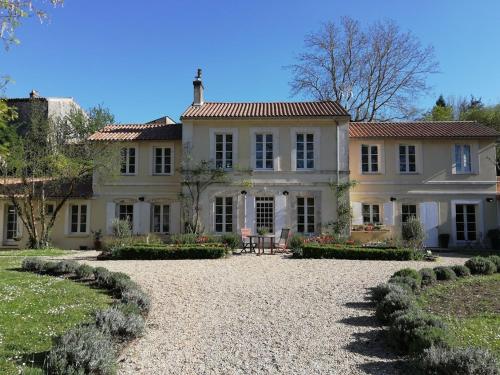 a large white house with a garden in front of it at Le Domaine Des Platanes in Bourg-Charente