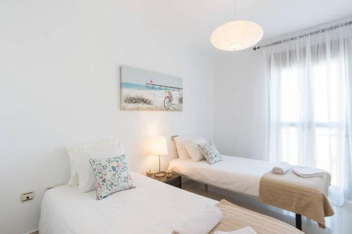 biały pokój z dwoma łóżkami i oknem w obiekcie TGH Málaga we love the sea w Maladze