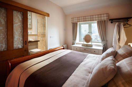 una camera da letto con un letto grande e una finestra di Rita's Luxury Retreat with Swedish Hot tub and Wood Fuelled Pizza Oven a Shrewsbury