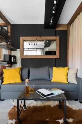 a living room with a blue couch and yellow pillows at Aparthotel Narciarska 2 in Korbielów