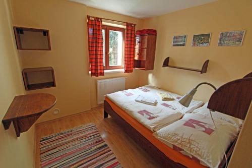een slaapkamer met een bed met een lamp erop bij Chaty Tatra in Tatranska Strba