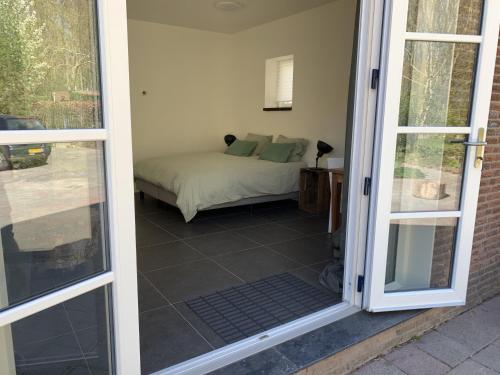 drzwi do sypialni z łóżkiem w pokoju w obiekcie Gastenverblijf De Viking w mieście Zuid-Beijerland