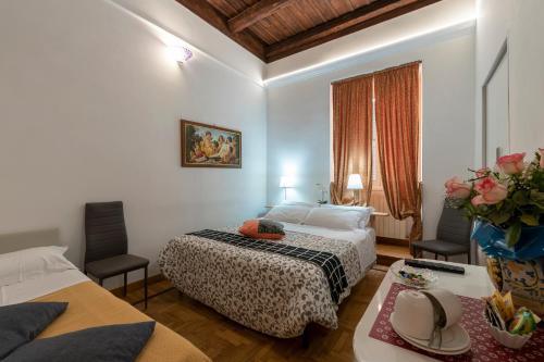 ローマにあるRoman Nightsのベッドと椅子2脚があるホテルの部屋