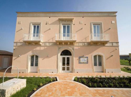 a large house with two balconies on top of it at Hotel Villa Fanusa in Siracusa