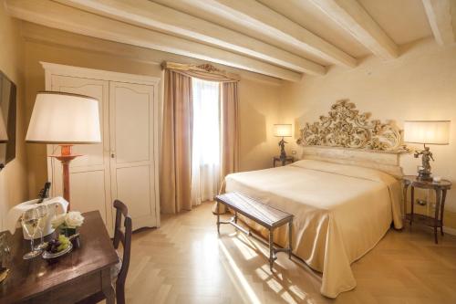 a bedroom with a bed and a table and a window at Relais Fra' Lorenzo in Verona