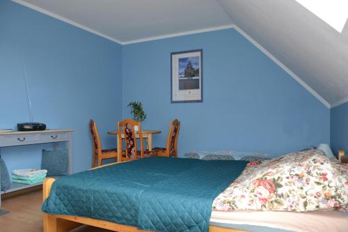 a blue bedroom with a bed and a table at Gospodarstwo Agroturystyczne Damroka in Szymbark