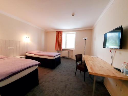a hotel room with two beds and a desk and a table at Hotel Pause in Hofheim am Taunus