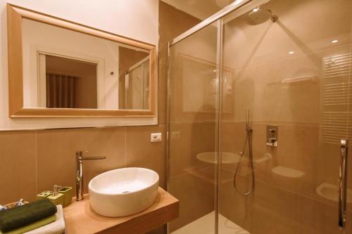 un bagno con lavandino e doccia in vetro di Casa Aricò & Shatulle Suites a Taormina