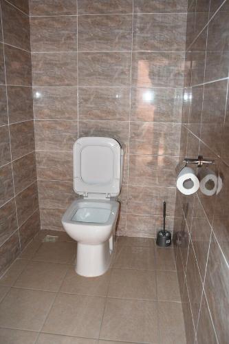 a bathroom with a toilet and two rolls of toilet paper at Santa Monica Home Lodge in Senchi