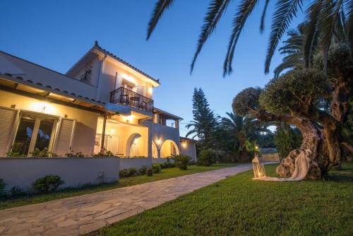 a house with a palm tree in the yard at Villa Phoenix in Keri