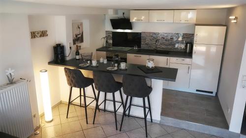 una cocina con encimera negra y taburetes de bar en Ferienwohnung Lieblingsnest, en Bernkastel-Kues
