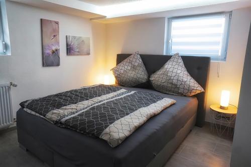 Un dormitorio con una cama con dos almohadas y una ventana. en Ferienwohnung Lieblingsnest, en Bernkastel-Kues