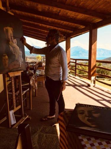 a man is painting a painting on a canvas at Il Rifugio del Contadino Art & Nature in Bosco