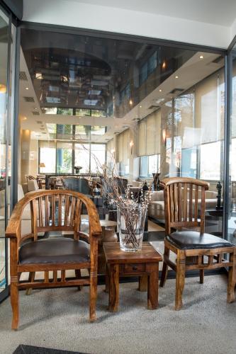 a lobby with three chairs and a vase on a table at Premier Agrinio Heart Hotel in Agrinion