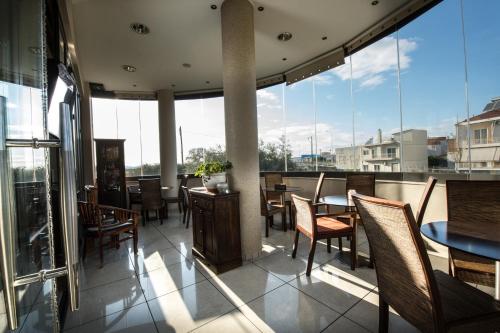 a restaurant with a balcony with tables and chairs at Premier Agrinio Heart Hotel in Agrinion