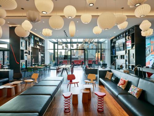 a living room filled with tables and chairs at citizenM Boston North Station in Boston