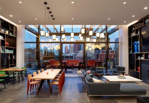 a restaurant with tables and chairs and a large window at citizenM Boston North Station in Boston
