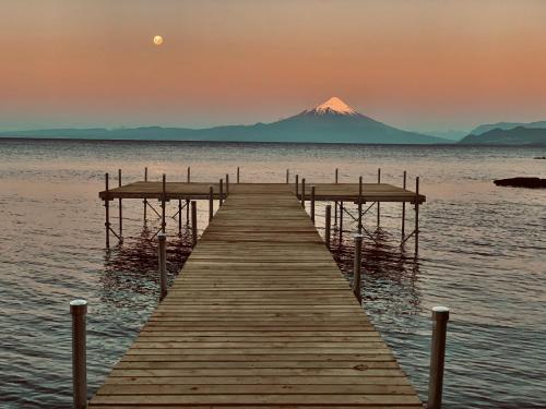 a dock in the water with a mountain in the background at Casa Molino Hotel Boutique & Restaurant in Puerto Varas