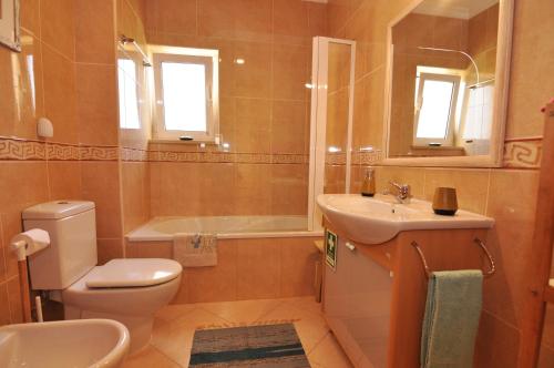 une salle de bain avec toilettes, lavabo et baignoire dans l'établissement Sunset at Vila da Praia, à Alvor