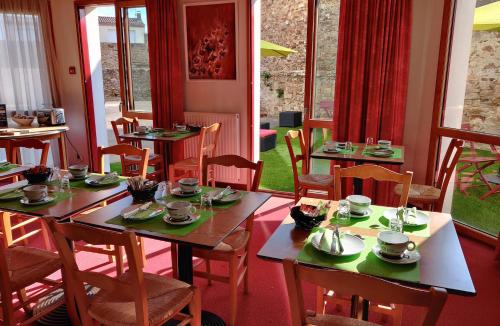 a restaurant with wooden tables and chairs with dishes on them at Hotel La Bosselle in Saint-Philbert-de-Grand-Lieu