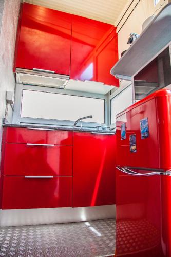a red kitchen with red cabinets and a refrigerator at Estudio Maignon in Barcelona